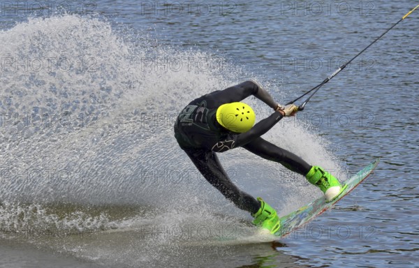 Russia, Volgodonsk - June 18, 2015: Water snowboard. The athlete with snowboard hold on to the rope