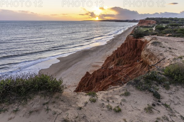 View from one, eroded cliffs of red sand and pebbles with stunning formations illuminated by a warm