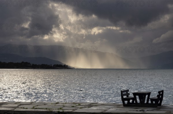 Empty picnic table in in the Norwegian village Herand in front of a dramatic sky over the