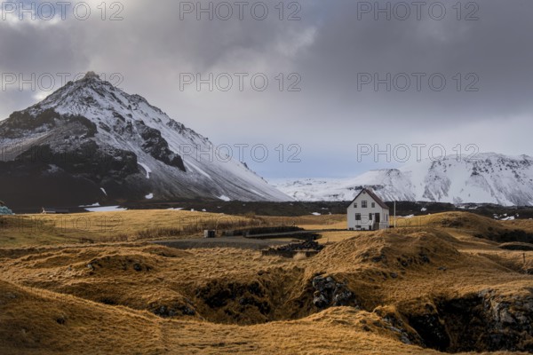 Lonely house on the basalt coast and Stapafell mountain near the snfellsjoekull glacier,