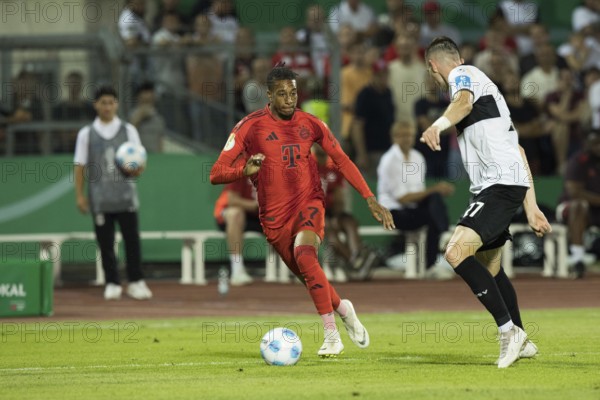 Football match, Michael Akpovie OLISE FC Bayern Munich left on the ball in a duel with Niklas KOLBE