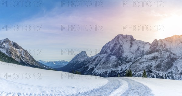 Winter landscape with a road made by a snowmobile, its traces through the layer of snow, in the