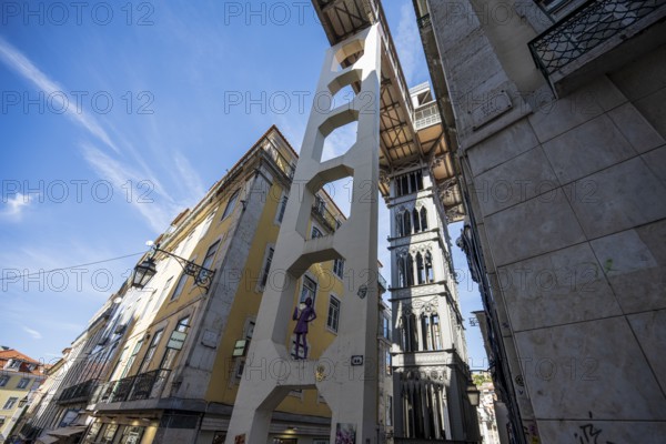 An urban area with historic buildings and an iconic lift under a blue sky in Lisbon, Elevador de