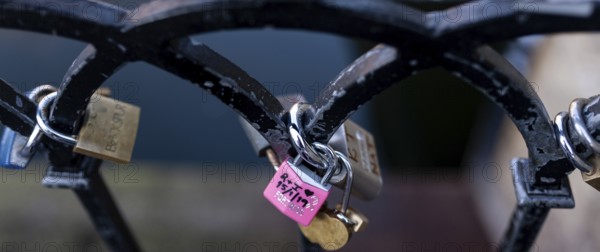 Colorful padlocks on a metal fence, including a pink love-themed lock in the London Borough of