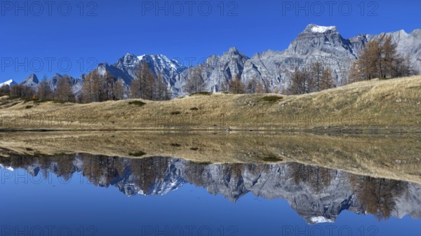 Majestic mountain landscape reflected in the calm lake under a clear sky, Pizzo Cornera 3083 m,