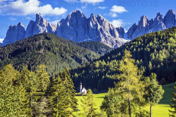 Dolomites, Tirol. Sunny warm autumn day. Rocky peaks and forested mountains surrounded by green