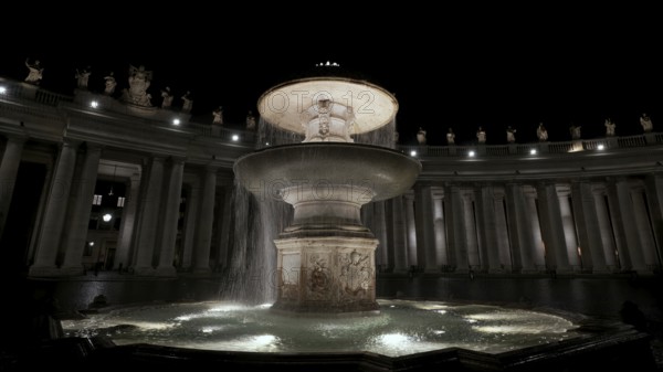 An illuminated night view of a flowing fountain surrounded by columns, Fontana del Bernini, St.