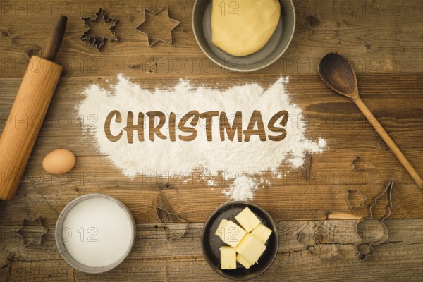 Collection of ingredients and utensils for baking Christmas biscuits with the word Christmas