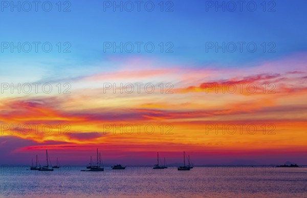 Yachts boats in front of the most beautiful colorful sunset at Tropical Paradise island Koh Phayam