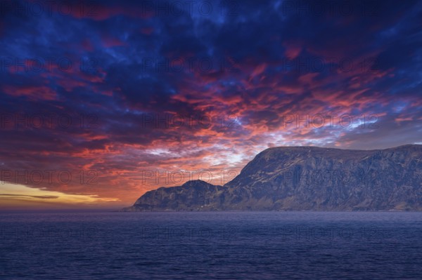 View from the sea to the West Cape in Norway at sunset with sun rays and heavy clouds. Waves in the