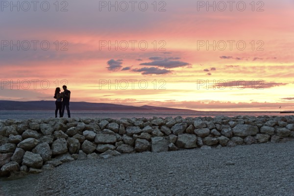 Sunset, couple on a pier, coast near Brela, behind them the island of Brac, Adriatic Sea,