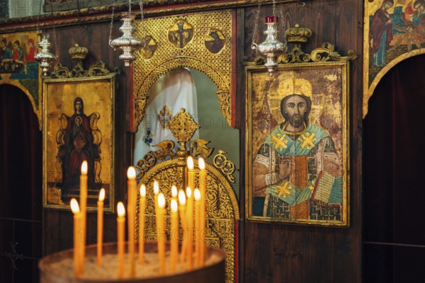 The interior of the church. Icons, chandelier, candles in a small Christian Orthodox church in