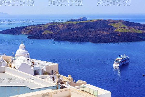 Santorini, Greece iconic view of white houses, church dome, caldera, volcano island and sea