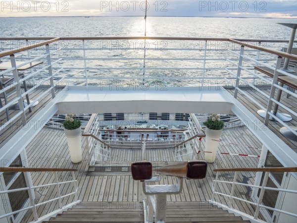 View of the deck of a ship at sunset with railings and a wooden staircase, svaneke, bornholm,