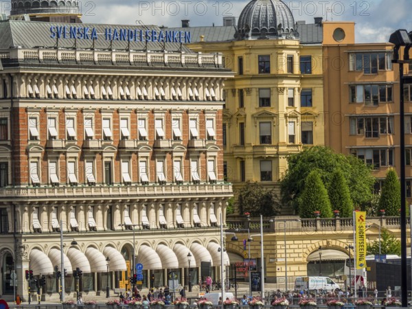 A row of architectural buildings with advertising signs and a cloudy sky above, stockholm, baltic