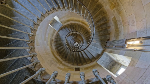 Interior spiral staircase of the Whale Lighthouse made of stone, showcasing intricate railing and