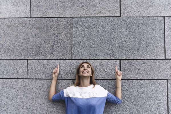 Cheerful girl at the street, show a big sale, or nice offer. Advertise concept. People, travel and