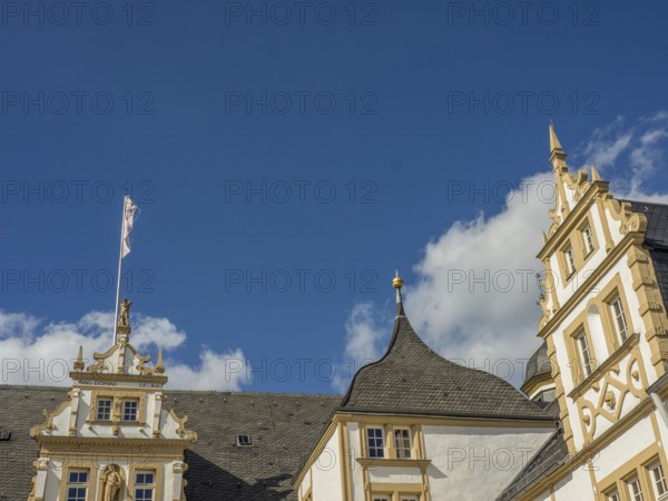 Historic castle with yellow and white façade and towers in front of a blue sky with clouds, Neuhaus