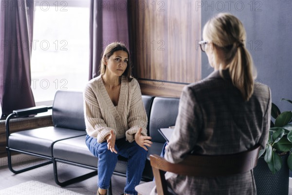 Eine junge Frau spricht in einem Gespräch mit einem professionellen Psychologen über ihre Probleme.