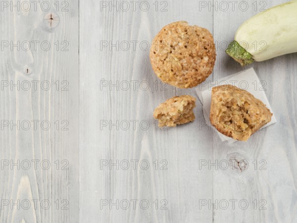 Top view of muffin with zucchini, carrots, apple and cinnamon on gray wooden background. Sweet