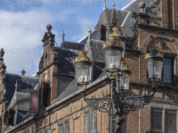 Historic building with ornate roof edges, in the foreground a decorative lantern under a slightly