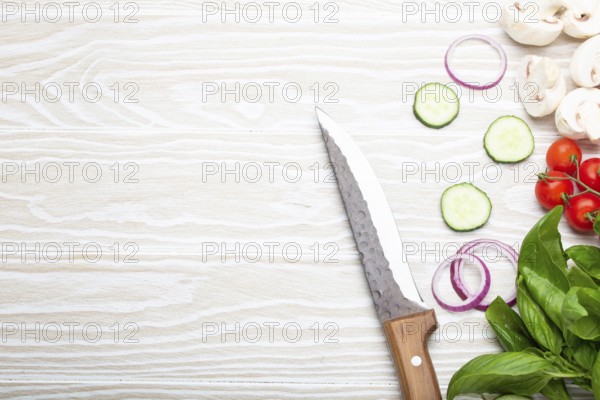 Food cooking background: fresh ingredients with kitchen knife, basil, cherry tomatoes, mushrooms,