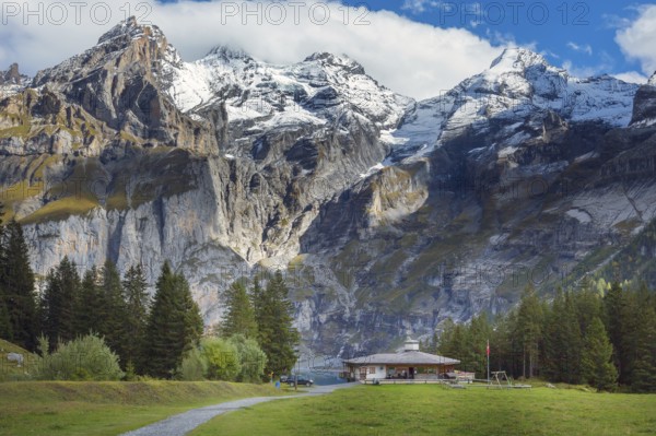Oeschinnensee lake, wooden chalet and Swiss Alps, Bernese Oberland, Switzerland panorama