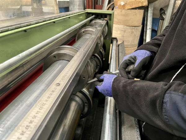 Technician worker placing the blades of a machine to cut steel coils. Industrial environment and