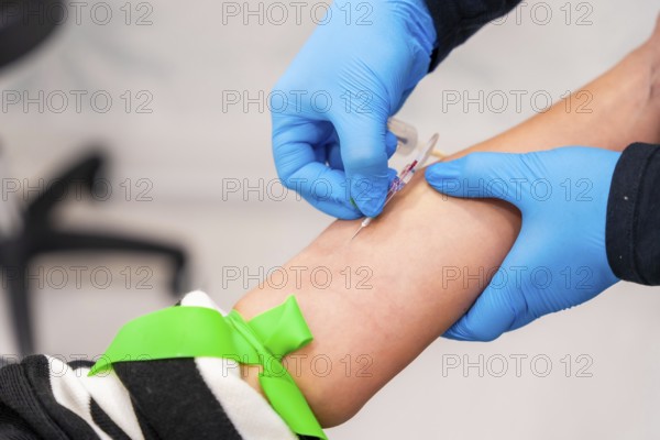 Close-up of nurse using needle to extract blood sample from a woman