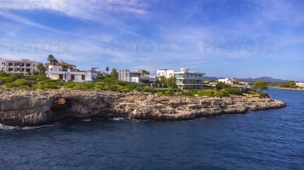 Stunning aerial view of the portocolom lighthouse and luxury villas perched on a rocky coastline in