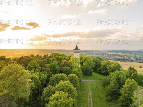 Tower at the edge of the forest, framed by trees, in the soft light of sunset, Engelbergturm,
