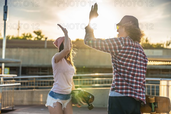 Two friends sharing a joyful high five after an exhilarating longboarding session, basking in the