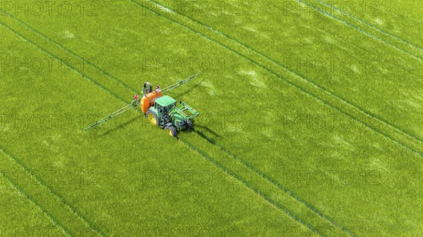 Farmer with tractor working in the field. In early summer, he fertilises the grain for an optimum