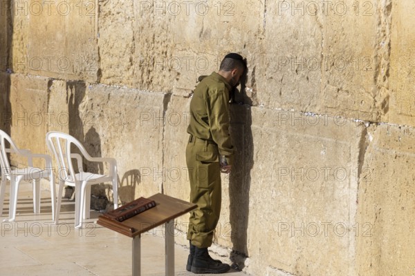 Jerusalem, Israel, 15 April, 2022: Israeli soldier praying in front of Sacred Western Wall in