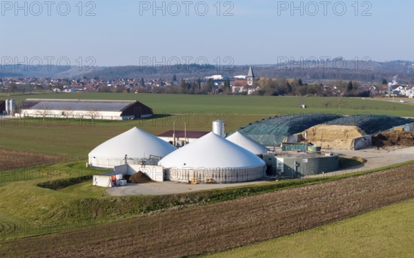 Modern biogas plant in a rural setting with a view of a village and wide fields, near Backnang,