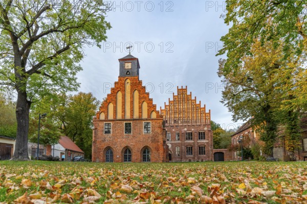 Autumn atmosphere with leaves in the meadow in front of Zinna Monastery with its brick