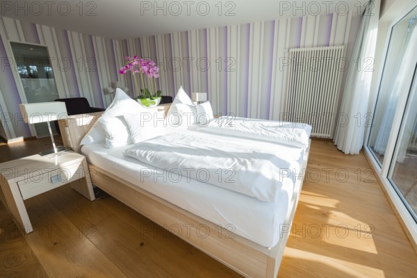 Bright bedroom with double bed, wooden floor and purple striped walls, Hotel Krone Lamm,
