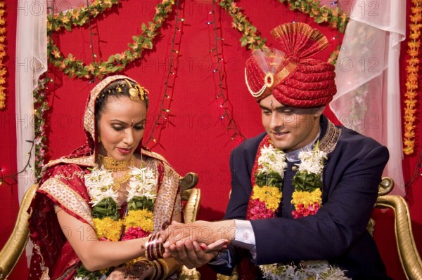 Indian bride and bridegroom holding hand performing vidhi in marriage ceremony MR Bridegroom#729E,