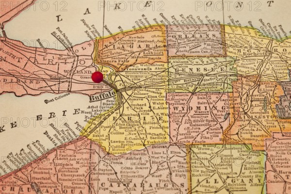 Buffalo and part of New York state on vintage 1920s map with a red pushpin, selective focus