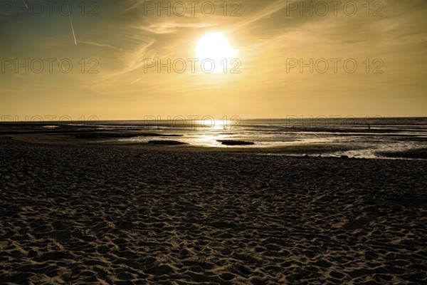 Golden sunset creates a warm atmosphere on a sandy beach, North Sea beach 27476