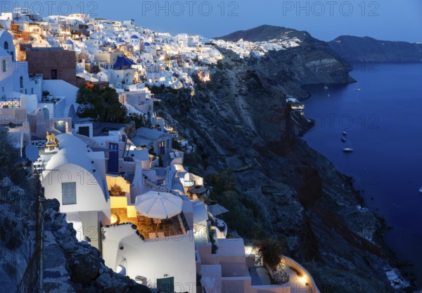 Blue hour after sunset, view from Oia to white buildings on the crater rim, Santorini, Cyclades,