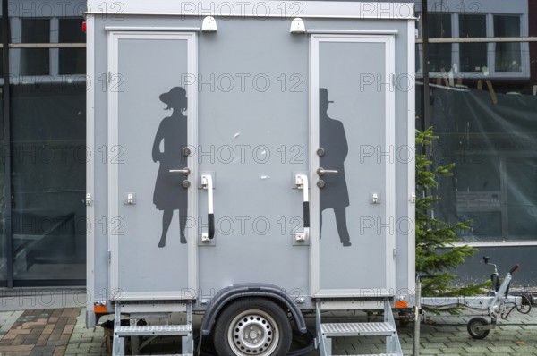 Modern portable toilet trailer with separate entrances for men and women, featuring elegant