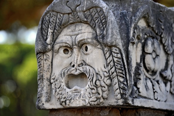Ancient stone sculpture, stone carving of a mask, Roman theatre, ancient port city of Rome,