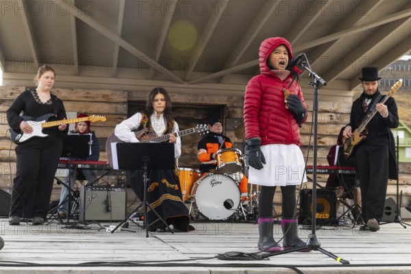 Girl sings with band at the reception for King Harald at the end of coal mining, Longyearbyen,
