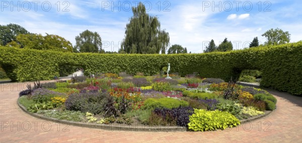 Lindenrund flower roundabout in Grugapark Essen, containing a bronze sculpture of a female javelin