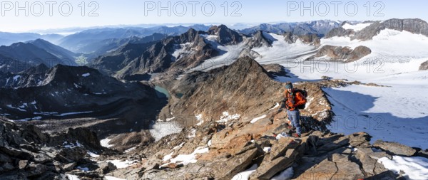 Mountaineer on a rocky ridge on the Wilder Freiger summit, behind him Signal summit and Becher