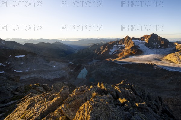 Picturesque high mountain landscape at sunrise with alpenglow, blue glacial lakes, glaciers and