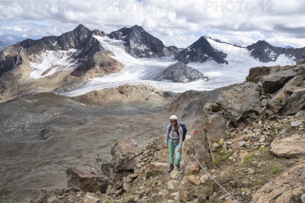 Mountaineer with helmet on a rope-insured path, in high mountain landscape, ascent to the Becher,
