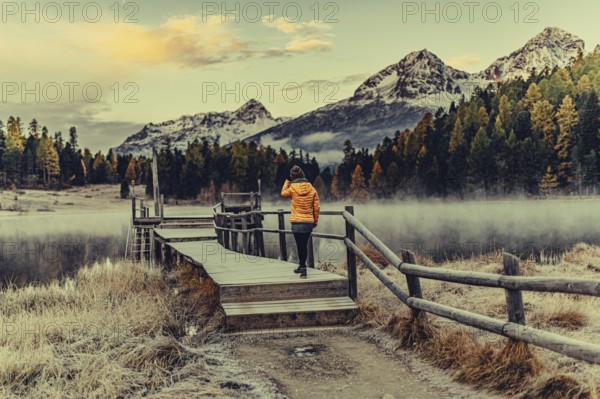 Young woman at Lake Staz near Sankt Moritz in the Engadine in Switzerland. Morning atmosphere with