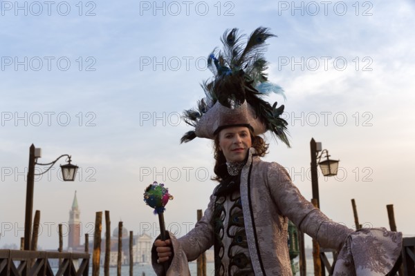 Tourist at the carnival, Venetian costume with hat, disguised man, boat dock at St Mark's Square,